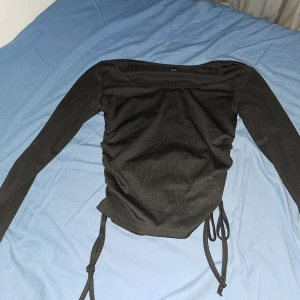 Svart teöja med rosetter på sidorna - En svart tröja med knyten på sidorna. Oanvänd💕 storlek M men passar xs/s