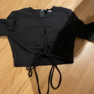 Svart topp  - En topp med öppning framtill 