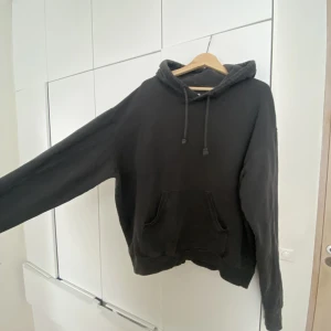 Hoodie - En svar/grå hoodie från Weekday med lite blekta detaljer