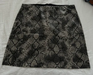 Ormmönstrad kjol - Orm mönster. Konstläder. Köpt på Gina Tricot. Använd 1 gång så i princip ny.