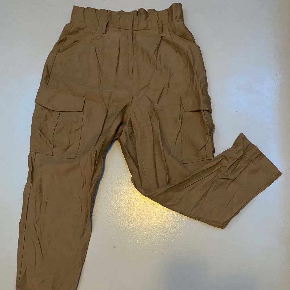 Beige/ bruna byxor från h&m, tunt material, skön inför sommaren, ser ut som cargo byxor, strl 40/M, 80kr + frakt. Jeans & Byxor.