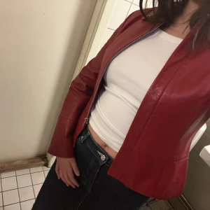 RÖD LÄDERJACKA  - Supersnygg röd läderjacka säljes. Inga skavanker eller dylikt, endast en liten fläck (se sista bild) säljes därför billigt. Jätremjukt läder. Strl: 38, upplevs mer som en 36. Vid snabb affär kan priset diskuteras. 