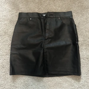 Skinnkjol  - Skinnkjol (skinnimitation) från H&M divided i storlek 38. Använd några få gånger men i bra skick. 