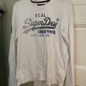 Superdry långärmad vit - Sportig vit långärmad tröja från Superdry. Tecken på användning men i gott skick övrigt!