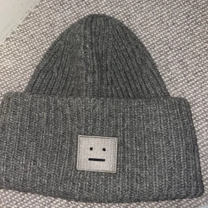 Grå acne mössa - En grå Acne mössa, äldre modell men lika, super fin grå acne mössa men en svart smile😀 hör av er vid frågor 