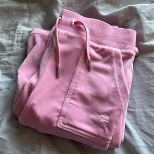 Juicy Couture byxor - Säljer mina rosa Juicy Couture byxor pga att jag inte använder dem längre. 💕Byxorna är uppsydda men kan lätt sprättas upp, sitter perfekt för mig som är 157cm lång. 💗Priset kan diskuteras vid snabb affär.💞Köparen står för frakten.