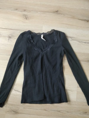 Svart tröja - Långärmad, ribbad svart topp med spets runtom halsringningen. Köpt på Sellpy och i bra skick!❤️