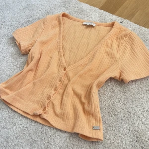 Aprikos Topp - Söt V-ringad topp från pull and bear i färgen aprikos (peach) Går att knäppa upp (skriv för fler bilder) Den är i storlek M men passar folk med S också!