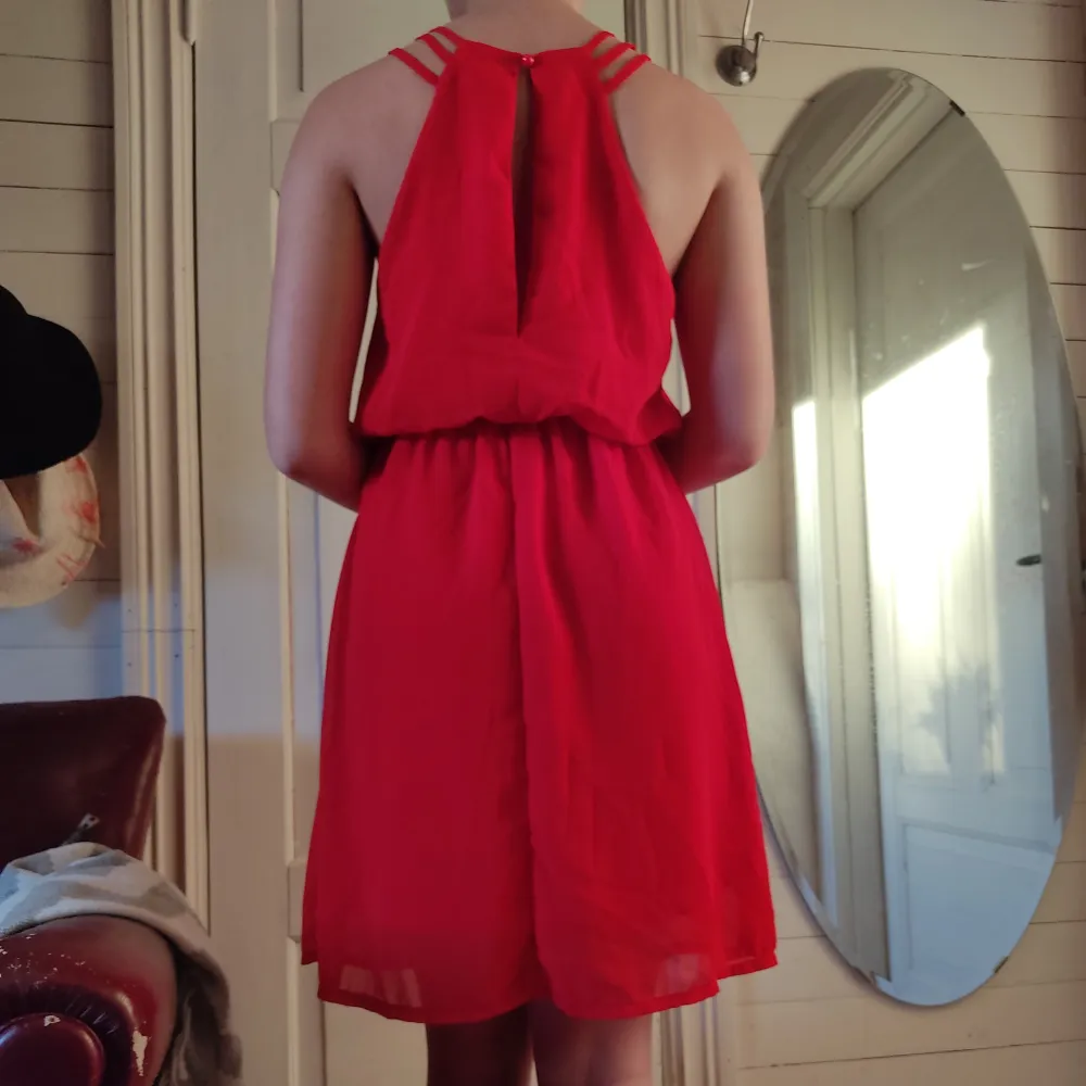 En starkt röd klänning med en öppning i ryggen. Klänningen har bara blivit använd typ en gång.. Klänningar.