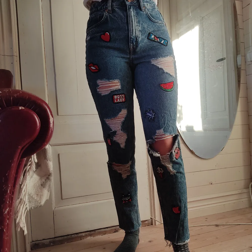 Ett par jeans med coola tygmärken av olika motiv påsydda. Jag köpte dem secondhand och har älskat dem men nu passar de inte. Det står att de ska vara str 36 men skulle säga att det nog passar en str 34 bättre.. Jeans & Byxor.