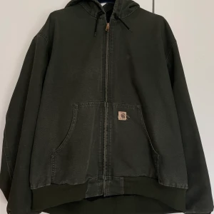 Carharrt workwear jacka - Säljer min kära carhartt jacka som inte kommer till användning längre. Köpt på ettresex för 2 år sen.  Står XL (sitter som L)  Har en liten distress/flaw som blivit ihopsydd. Enligt mig så är det ganska najs och bidrar till känslan. 