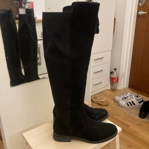 Ett par stövlar med högt skaft storlek 39 - Låga stövlar i svart mockaimitation och högt skaft. Storlek 39.