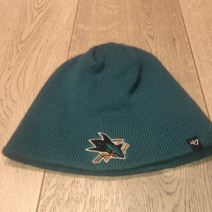 Blå haj mössa - En riktig dope mössa, tror att det är ett hockey lags mössa, knappt använd, bra skick ✨ 