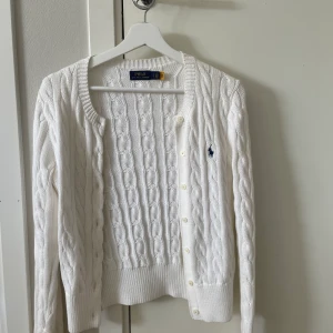 Vit Ralph lauren kofta  - Super snygg vit kabelstickad kofta ifrån Ralph Lauren💘 Inte mycket använd alls! Nypris: 1599kr 
