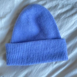 Arket Mössa - Stickad mössa från Arket. Den är med lila i verkligheten, färgen blev inte så rättvis på bild.  Endast använd ett fåtal gånger. I nyskick! Kan mötas upp i Stockholm.