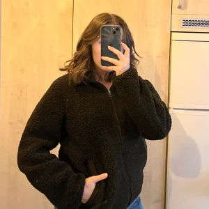 Mörkgrön teddyjacka från uniqlo strl s - Jättefin och mysig mörk-/olivgrön Teddyjacka från uniqlo, strl s. Jag tror det är en herrmodell men jag har använt den så därför satte jag unisex. Ursprungspris 400kr 