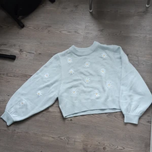 Ljusblå stickad tröja med blommor - Stickad tröja från HM Divided "To all the boys". Blommor/Prästkragar på framsidan. Aldrig använd🌼