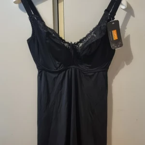 Svart underklänning/nattlinne/negligee 80H - Ny med tags! Svart nattlinne/underklänning med riktiga BH-kupor från LupoLine.  Snittet är något utsvängt och passar bra till kurvigare figurer.  Märke: Lupo Line Storlek: 80H Material: 85% polyamid och 15% elastan
