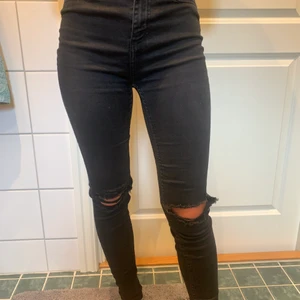 Svarta jeans  - Svarta högmidjade skinny jeans med hål i knäna från lager 157 