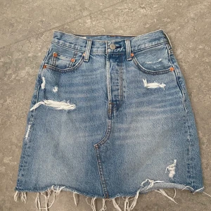 Jeanskjol Levis  - Jag säljer min Levis jeanskjol som aldrig är använd. Den är väldigt fin och perfekt för sommaren. Köpte för 800kr säljer för 600kr.