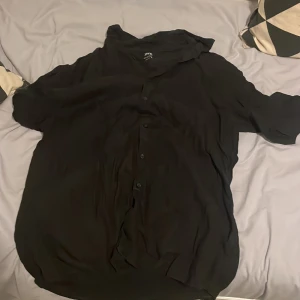 Svart linneskjorta från Zara - Säljer en stilren svart skjorta från Zara i 100% linne. Skjortan har korta ärmar och knappar framtill. Perfekt för en avslappnad men ändå snygg look. 🖤