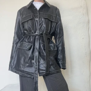 Oversized skinnjacka med knytning  - Oversized skinnjacka med knytning fram, alla lappar bortklippta men är från Gina tricot. En knapp saknas. 