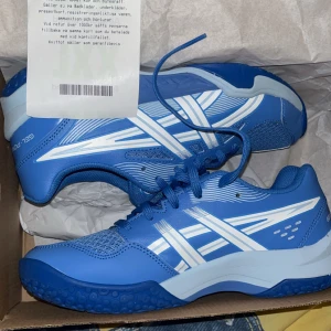Asics inomhusskor för barn - Inomhusskor för sport i storlek 39. Skorna är använda en gång inomhus, kvitto och kartong finns kvar. Nypris: 849kr