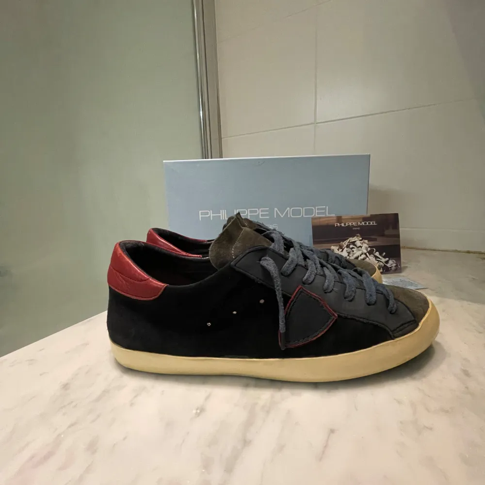 Snygga Philippe Model sneakers i färg mörkblå med röda detaljer. Skorna har en klassisk design med snörning och en bekväm sula. Perfekta för en stilren look.. Kengät.