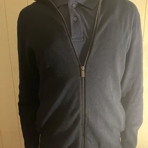 Svart/blå Massimo futtiga fullzip  - Säljer en stilren svart långärmad Massimo Dutti tröja med dragkedja framtill. 