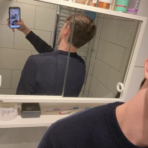 Mörkblå ulltröja från Vailent - Säljer en stilren mörkblå tröja från Vailent i merinoull. Tröjan har långa ärmar och en klassisk rund halsringning. Perfekt för kyliga dagar och ger en elegant look.