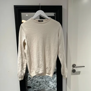 Beige/vit tröja från Cavalli Class - Säljer en stilren beige/vit tröja från Cavalli Class. Tröjan har en klassisk rund halsringning och långa ärmar. Perfekt för en elegant och avslappnad look. Aldrig använd.