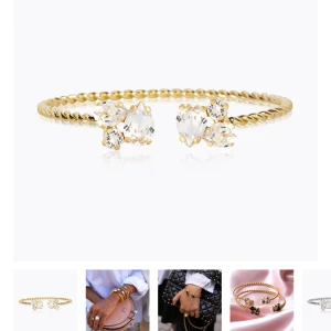 Guldarmband med kristaller - Elegant guldarmband med tvinnad design och gnistrande kristaller i båda ändar. Perfekt för att lägga till en touch av glamour till din outfit. Armbandet är justerbart och passar de flesta handleder. 