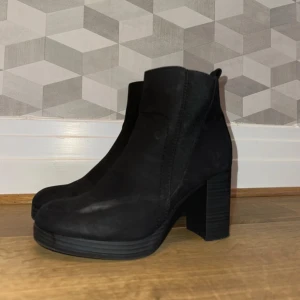 Svarta boots med klack - Snygga svarta boots med klack och rundad tå. Perfekta för att ge lite höjd och stil till din outfit. De har en enkel design som gör dem lätta att matcha med olika kläder.