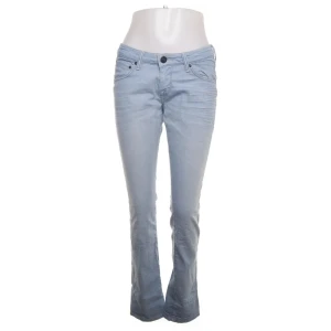 Ljusblå lågmidjade bootcut jeans - Snygga ljusblå bootcut jeans från Lee med klassisk femficksdesign och knappgylf. Perfekta för en avslappnad stil med en touch av retro. Midjan är normalhög och byxorna har en bekväm passform.