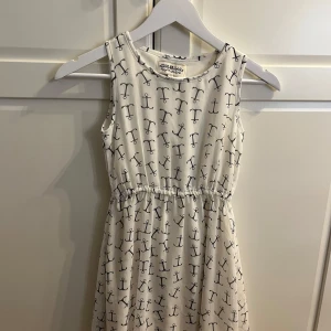 Vit ärmlös klänning med ankarmönster från Hampton Republic - Säljer en söt vit ärmlös klänning från Hampton Republic med ett stilrent ankarmönster i marinblått. Perfekt för en somrig dag vid havet eller en avslappnad utflykt. Klänningen har en bekväm passform och är gjord i ett lätt material.