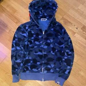 Bape Full Zip Hoodie i blå - Bape Full Zip hoodie i färgen blå. Endast använd några gånger/Bra skick. Storlek L men sitter som en M