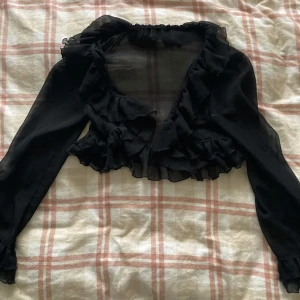 Svart bolerotopp - Snygg svart genomskinlig bolerotopp med volangdetaljer och långa ärmar 💗Priset går att diskuteras !