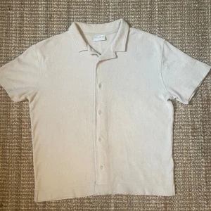 Kortärmad skjorta av froté - En kortärmad skjorta som är perfekt för vår och sommar. Materialet är av mjukt froté. Den är helt i nyskick, därav priset. Men priset kan gå att diskutera vid snabb affär. 