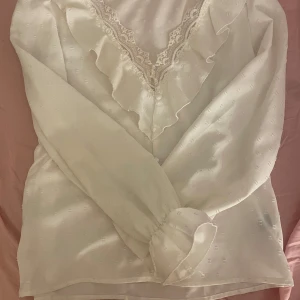 Vit blus - Säljer en jättegullig vit blus från SHEIN i storlek XS, spets uppe i kragen och är V ringad. Sitter lite lösare beror såklart på kropp men enligt mig är det inte en tight passform.