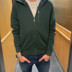 Grön zip hoodie från Sail racing - Säljer en mörk grön zip hoodie från Sail Racing. Storleken är S. Om de är några frågor är de bara att skriva. Priset är ej hugget i sten