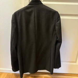 Tiger of Sweden Kavaj/Kostym - Säljer min Tiger of Sweden Kostym/kavaj som jag har ärvt av farsan. Säljer den pga av att den är lite för stor för mig. Kavajen passar för den som har breda avxlar/är på plussidan eller de som vill gå för oversized stilen. Kavajen är i nästan perfekt tillstånd. Är osäker vilken storlek det är i siffror men Axel måtten är 55cm+