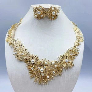 Guldhalsband och örhängen med pärlor - Elegant set med halsband och matchande örhängen i guld. Designen har ett unikt mönster med strålande detaljer och vackra pärlor som ger en lyxig känsla. Perfekt för att lyfta vilken outfit som helst.