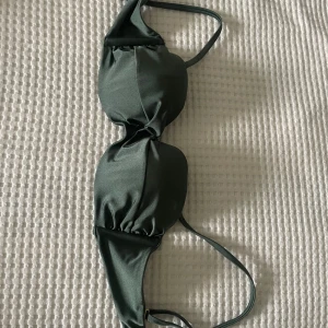 Olivgrön bikiniöverdel - Säljer denna olivgröna bikiniöverdel, knappt använd och har inga defekter, bikinin är från HM och är i storlek 75 C 💚