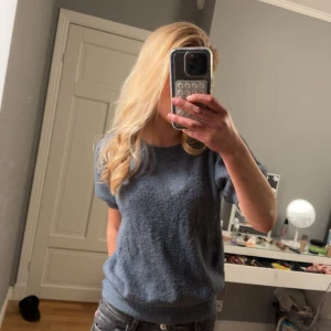 Blå stickad tröja - Säljer en mörk grå stickad tröja med korta ärmar. Perfekt för kyligare dagar och enkel att matcha med olika outfits. Tröjan är i storlek M  men passar S, skulle säga att den mer är som S!! Hör av er vid frågor❣️❣️
