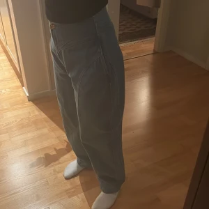 &OtherStories jeans  - Snygga blå jeans med hög midja och en loose passform. Byxorna har en unik sömdetalj framtill och bak, vilket ger dem en modern look. Perfekta för en avslappnad stil.