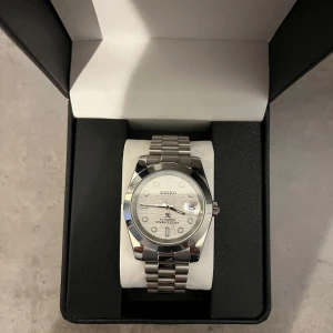 Seiko mod  - Utrustad med ett automatiskt urverk från Seiko NH35. Klocklåda samt verktyg för att ta bort länkar medföljer.  Vid frakt, packar vi klockan säkert. Hör av er vid fler frågor/bilder!