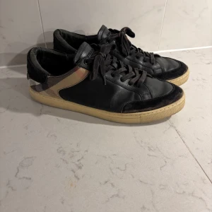 Svarta Burberry sneakers  - Svarta Burberry skor. Med det klassiska mönstret vid hälen. 
