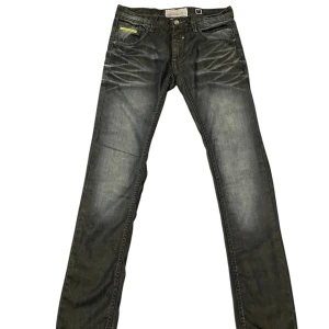 Gårsvarta Jeans  - Snygga svarta jeansbyxor från med en cool tvättad look. Byxorna har en klassisk femficksdesign och knappgylf. Perfekta för en stilren och avslappnad stil. 