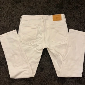 Vita jeans från Jack & Jones - Snygga vita jeans från Jack & Jones med klassisk femficksdesign. Perfekta för en stilren look. Märkeslappen i läder på baksidan ger en extra touch av kvalitet.