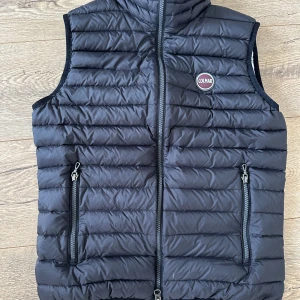 Svart dunväst från Colmar - Säljer en populär svart dunväst från Colmar. Använd men ok skick. Kan vara i behov av tvätt. Jag köpte den på här på Plick nyss för 800kr men det sitter en parfymlukt kvar i den därav billiga priset. Jag skulle säga att de är små i storlekarna. 